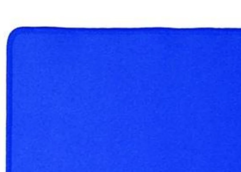 Close-up of a BCW Spectrum playmat's rounded corner, showing the darker stitched line that runs along the fabric edge